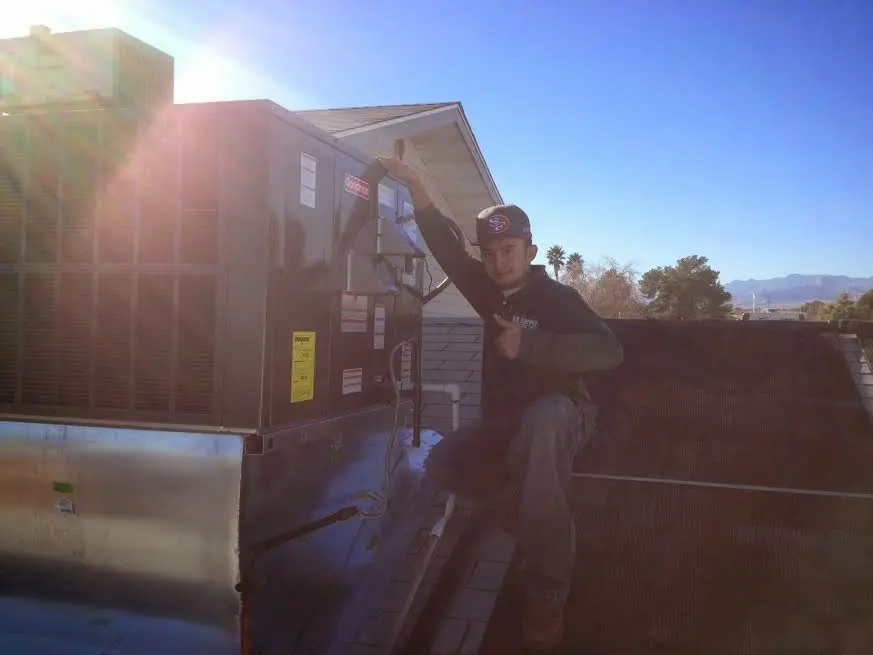 HVAC technician performing AC Tune-Up on a rooftop unit in La Quinta